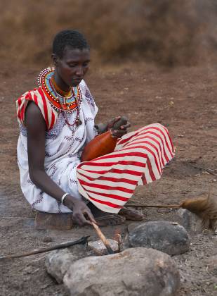 Maasai Starting a Fire Maasai woman lighting a fire, seen in Kenya.
