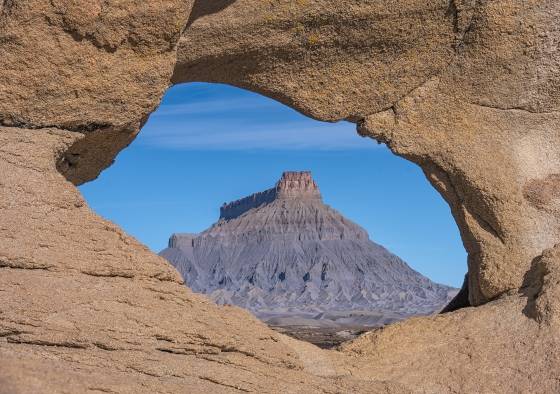 One Hole Arch early morning Arches framing Factory Butte near Hanksville, Utah