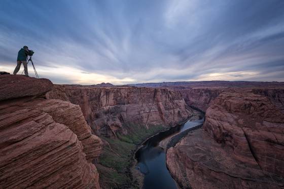 Great Clouds Photographer shooting the Colorado River at Horseshoe Bend near Page, Arizona