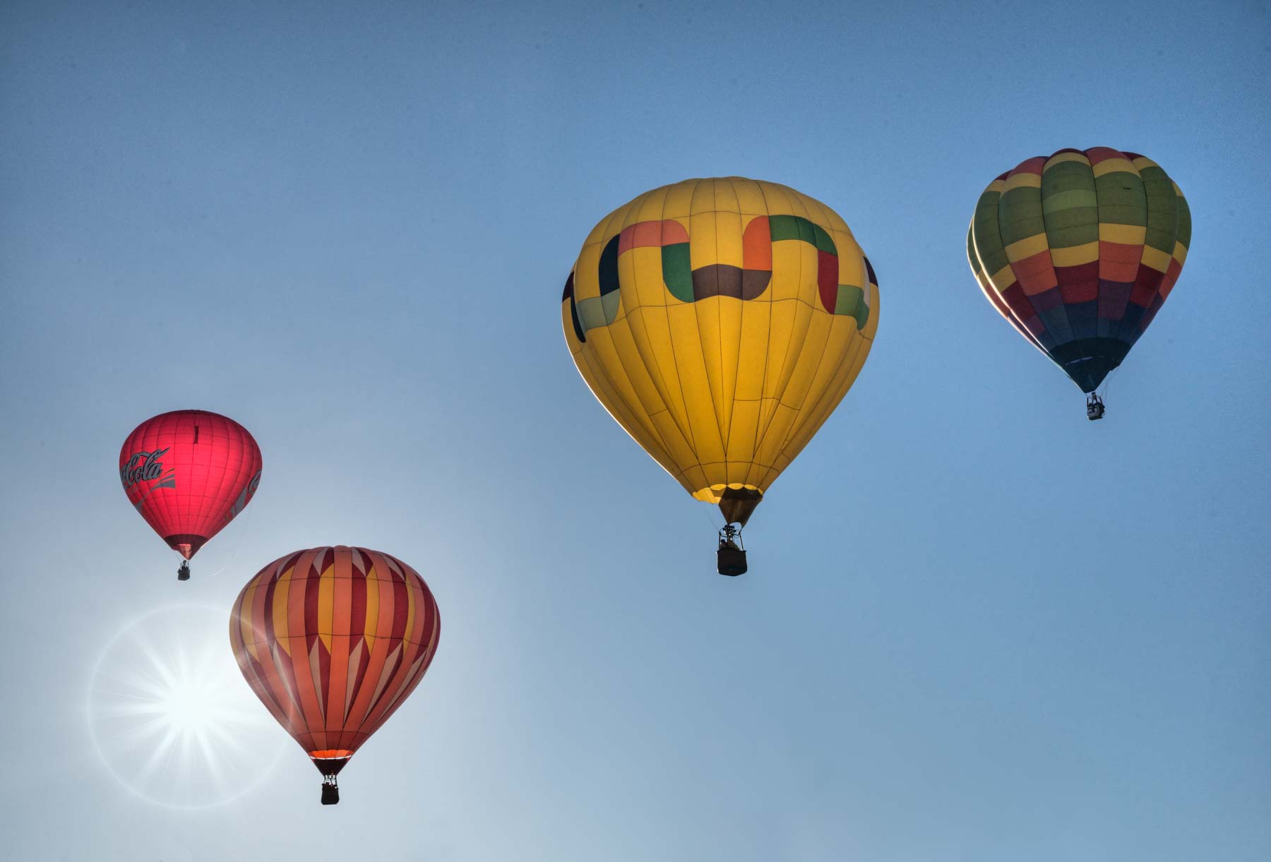 Backlit balloons in flight at the Page Balloon Regatta