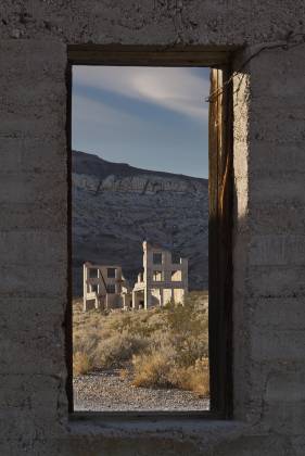 Cook Bank framed by jailhouse window Jailhouse and Cook Bank in Rhyolite ghost town, Nevada