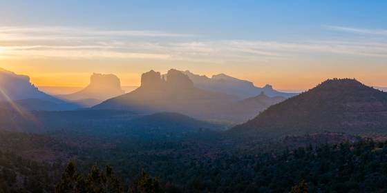 Sunrays Sun risiing over Lee Mountain in Sedona. Cathedral Rock and Courthouse Butte are shonw in the center. of the image.