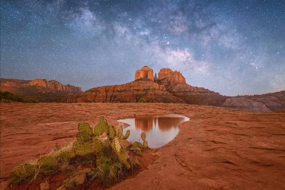 Reflecting on a Starry Night The Milky Way rising over Cathedral Rock reflected in a water pool on the Secret Slickrock Trail, Sedona.