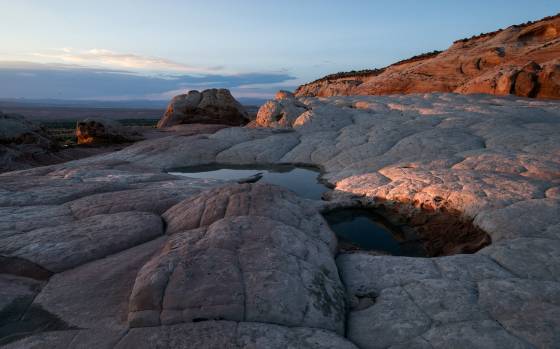 Last light on Moqui City Moqui martbles lying in Polygonal cracks at The White Pocket